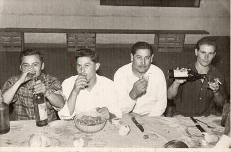 Foto en blanco y negro de un grupo de personas alrededor de una mesa

Descripción generada automáticamente